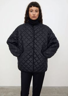 Totême's quilted jacket cut from a recycled polyester fabric. It’s designed for an oversized fit and shaped to a boxy silhouette with a round neck, dropped shoulders, press buttons, side pockets, and a rounded hem that is longer at the back, creating a chic A-line shape in profile. Layer over a turtleneck on your daily commute. Oversized Quilted Jacket For Workwear, Oversized Black Quilted Outerwear, Oversized Quilted Nylon Outerwear, Oversized Quilted Long Sleeve Jacket, Oversized Puffer Jacket With Pockets For Work, Oversized Quilted Outerwear With Long Sleeves, Oversized Quilted Long Sleeve Outerwear, Oversized Quilted Jacket For Fall Workwear, Oversized Puffer Quilted Jacket With Long Sleeves