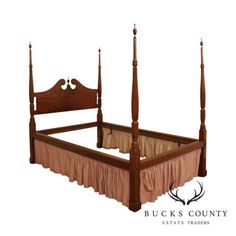 a wooden bed with four posts and pink bedspread