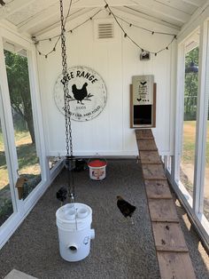 the inside of a chicken coop with two buckets and a ladder hanging from it's ceiling