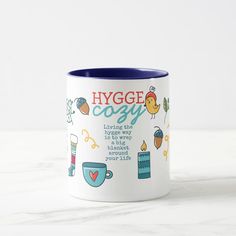 a coffee mug with the words hygge cozy written on it and images of food