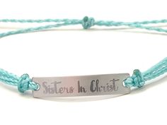 "This is an engraved waterproof bracelet, It is shown with an engraved brushed stainless steel bar and mint straps. You can choose your metal color and strap color. The bar will be engraved with \"Sisters in Christ\". You can choose back side engraving for personalization during checkout. Please let us know if you have any questions! The back can also be engraved. CHARACTER LIMIT- 14 characters per side Each item is made-to-order, which gives our pieces a unique meaning that is specific and spec Adjustable Engraved Name Bracelet For Friendship, Adjustable Stainless Steel Name Bracelet With Engraving Option, Adjustable Stainless Steel Bracelets With Engraved Text, Adjustable Stainless Steel Bracelet With Engraved Text, Inspirational Adjustable Silver Name Bracelet, Inspirational Engraved Adjustable Name Bracelet, Inspirational Silver Adjustable Name Bracelet, Inspirational Engraved Name Bracelet, Adjustable, Inspirational Silver Name Bracelet Adjustable