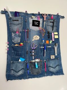 the back pocket of a jean purse is filled with various personal items and pens, scissors, pencils