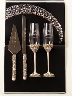 three wine glasses and two knives on a black background with gold glittered decorations around them