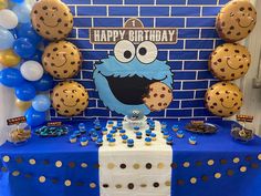 a cookie monster themed birthday party with blue and gold balloons, cookies, and cupcakes