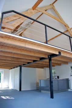 an empty room with wooden beams and metal railings