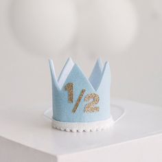 a small blue crown with gold numbers on it