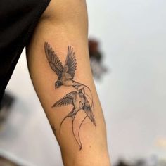 a tattoo on the arm of a woman with a bird