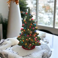 a small christmas tree sitting on top of a blanket