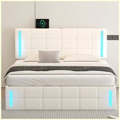 a white bed with blue lights on the headboard and foot board in front of it