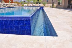 an empty swimming pool with blue tiles on it