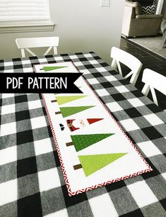 a table with a black and white checkered table cloth that has christmas trees on it