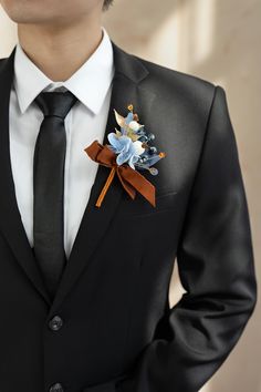 a man wearing a suit and tie with a boutonniere on his lapel