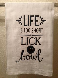 a tea towel hanging on a clothes line with the words life is too short, lick the good out