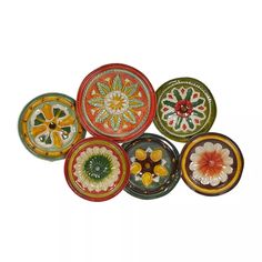 six colorful plates with designs on them sitting next to each other and one has an orange flower in the center