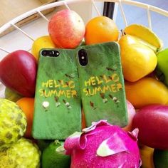 two cell phones sitting on top of a pile of fruit