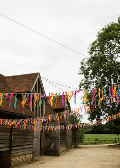 colorful streamers hang from the roof of an old barn