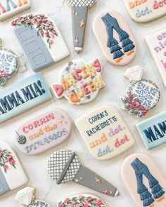 decorated cookies with the names of different countries are on a white table top, surrounded by magnets