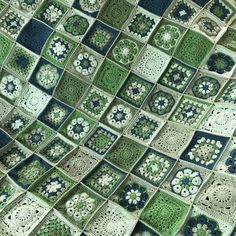 a crocheted blanket with green and blue squares on it's sides, in the shape of granny grannys