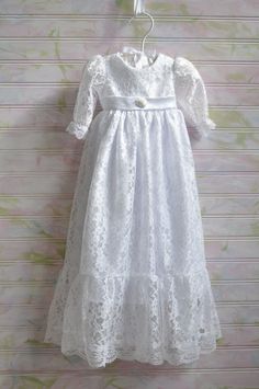 The "Madison" is a fully lined all over lace dress that measures approx 26" from shoulder to the bottom hem. There is a 7" ruffle on the bottom of the skirt that is included in the measurement.  There is lace detail on the bottom hem and the edge of the sleeve.  The sleeves are long as shown in the picture but can be made into short sleeves if desired. There is a elegant embellishment on the waist of the bodice.  Long ties for a bow finishes the back of the dress.  Button closures in the back. Lace trim on sleeve and bottom edge of dress may vary due to lace availability. Formal Lace Dress With Scalloped Detail, Fitted Gown With Lace Patchwork For Spring, Lace Bodice Fitted Dress, Spring Formal Lace Gown, Formal Lace Gown With Delicate Details, Formal Delicate Lace Gown, Fitted Lace Trim Dress For Baptism, Fitted Lace Bodice For Spring, Fitted Gown With Delicate Lace