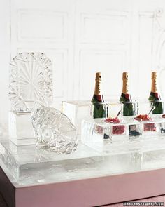 four bottles of champagne sitting on top of an ice block