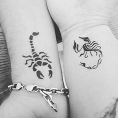 two people holding hands with tattoos on their arms and wrist, one has a scorpion tattoo