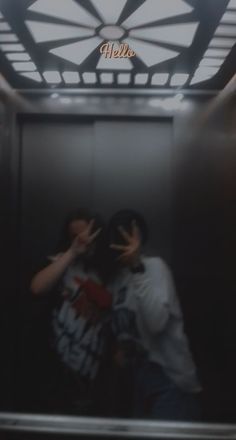 two people standing in an elevator with their arms around each other