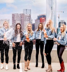 four women standing in front of a city skyline