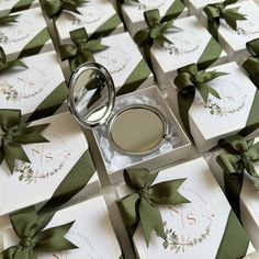 a ring sits on top of some cards with green ribbons around it and is surrounded by bows