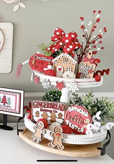 a three tiered tray with gingerbread cookies on it and some cards in the middle