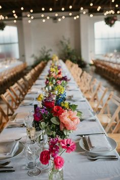 a long table is set with flowers and wine glasses