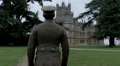 a man in uniform is walking towards a castle