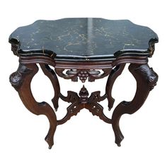 an ornately carved table with black marble top