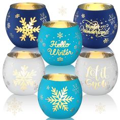 four blue and white snow globes with gold lettering on the sides, all decorated with snowflakes