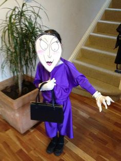 a person in a purple dress holding a black purse and wearing a fake handbag