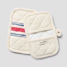 two white oven mitts with red, white and blue stripes on them sitting next to each other