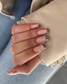 a woman's hand with long, shiny nails holding a beige purse in her left hand