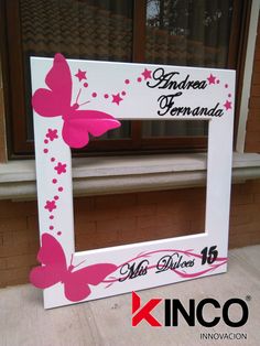 a white frame with pink butterflies and stars on the side, sitting in front of a window