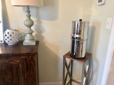 a table with a lamp on it next to a wooden cabinet