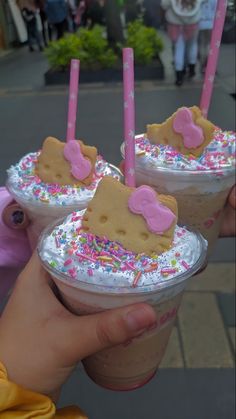 two cups with ice cream, sprinkles and hello kitty toppings on them