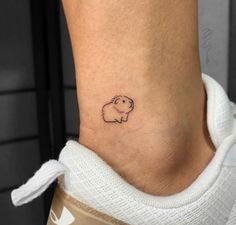 a small tattoo on the ankle of a woman's foot with a little hippo