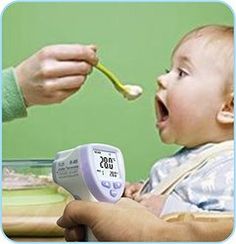 a baby is being fed with a thermometer