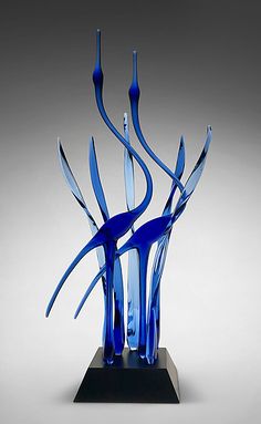 a blue glass sculpture sitting on top of a black base