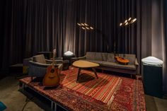 a living room filled with furniture and a guitar