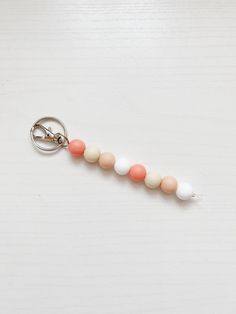 a keychain with three different colored beads attached to it on a white surface