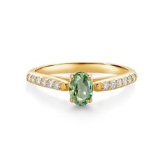 a gold ring with an oval green stone and diamonds on the band, set in yellow gold