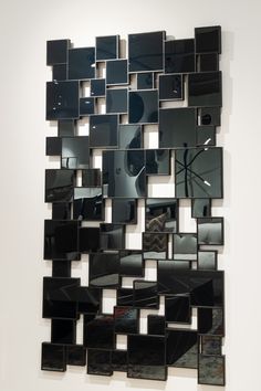 a mirror that is on the wall in front of some kind of art work,