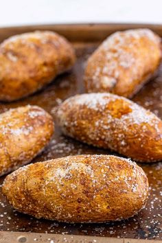 baked goods sitting in a baking pan covered with sugar and sprinkled with powdered sugar