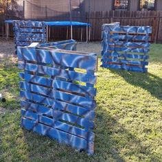 two blue wooden crates sitting in the grass