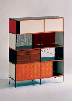 an orange and black cabinet with drawers on it's sides, against a white background