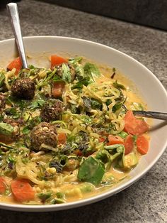 a white bowl filled with pasta and meatballs